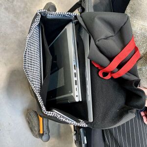 Saccoche accrochée au fauteuil ouverte, contenant un pc portable fermé